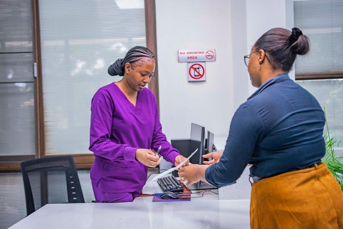 A nurse helping a patient at the IHZ reception desk